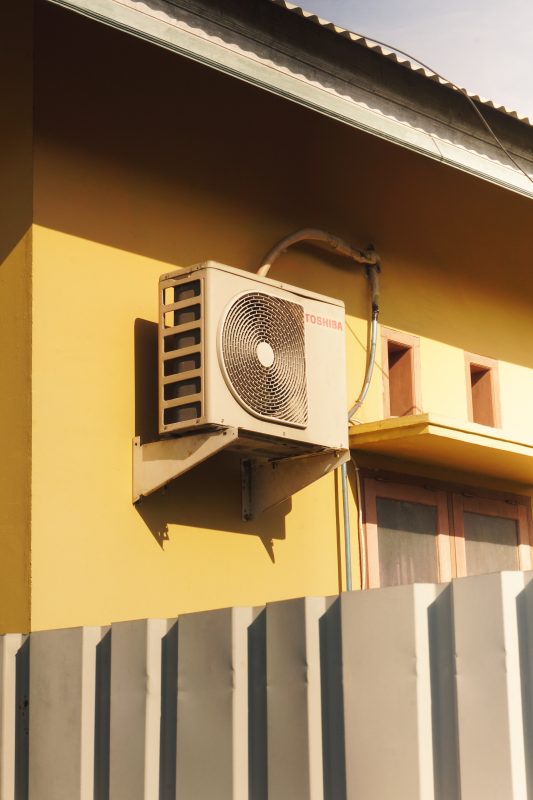 Toshiba outdoor air conditioner unit on yellow wall